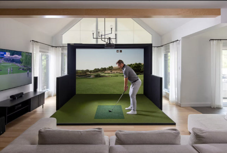 Golf simulator setup in a living room with a person playing golf on a screen.