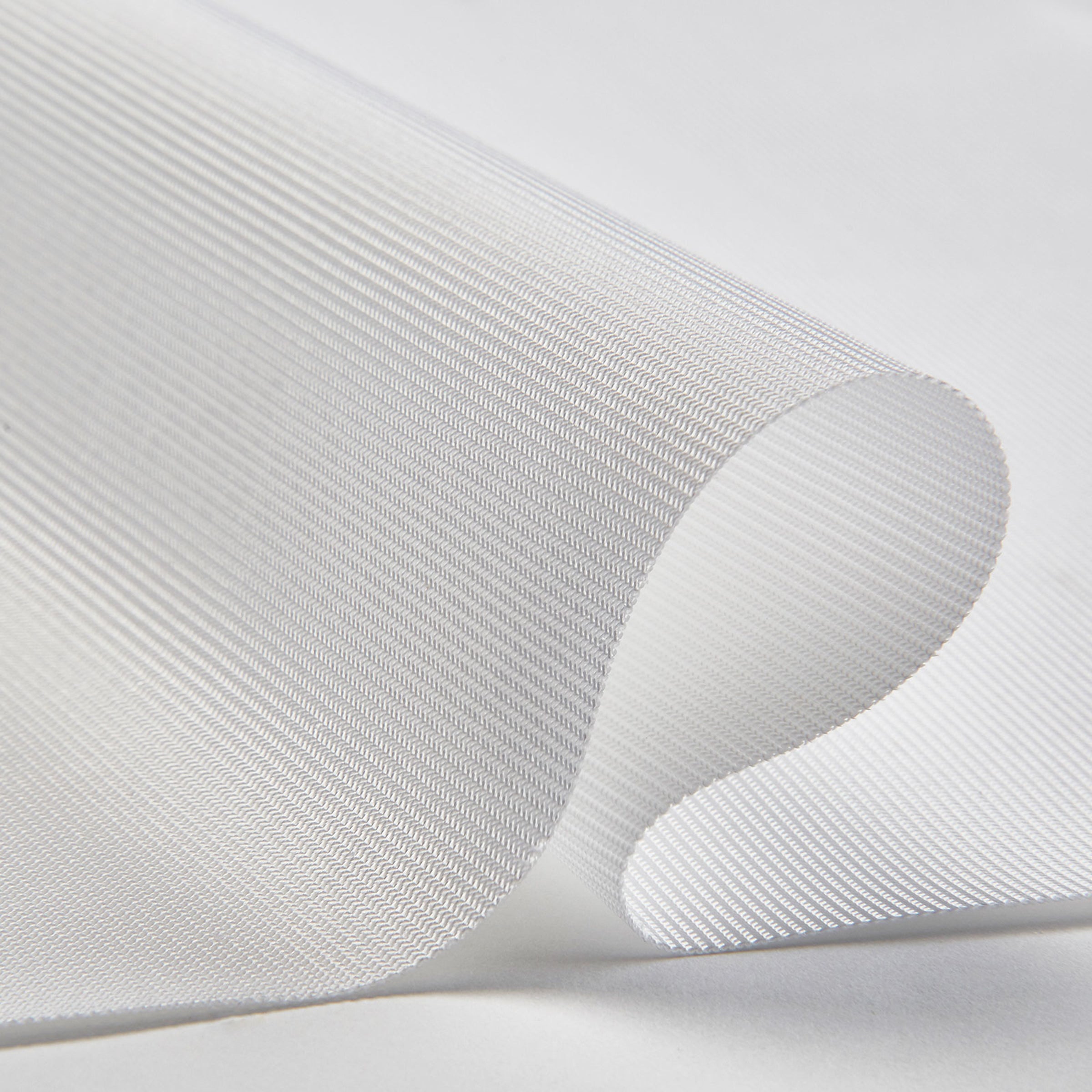 Close-up of white mesh fabric with a subtle pattern on a light gray background