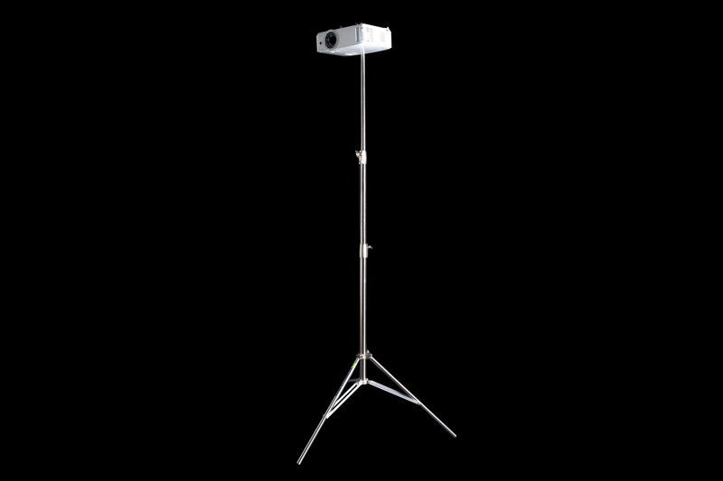 Projector on a stand against a black background